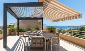 Dos opciones para disfrutar del exterior: una pérgola moderna y un toldo a rayas, ideales para saber como cerrar una pergola de madera y crear tu espacio.