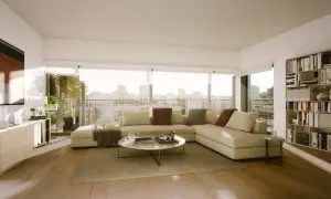 Elegante decoracion salon con sofá modular beige, mesa de centro redonda, estantería llena de libros y vistas a la ciudad.