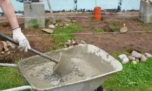 Mezclando cemento y agregados en una carretilla para saber como hacer hormigon.