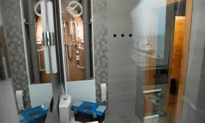 Herramientas listas para instalar mampara ducha esquina. Baño moderno con tuberías visibles y vista al mar.