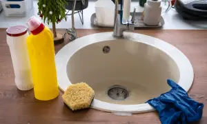 Prepara tus guantes y productos de limpieza para saber como desatascar un lavabo. Esponja, botellas y un lavabo listo para la acción.
