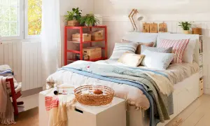 Acogedora habitación pequeña para adultos con cama, estantería roja y ventana luminosa.