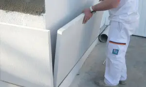 Obrero instala paneles de poliestireno expandido para aislamiento térmico, como si fueran sate en ventanas.