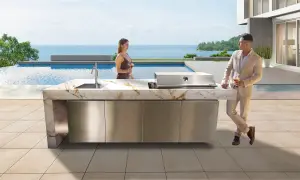 Pareja disfruta de cócteles junto a una piscina infinita, con una moderna cocina exterior y barbacoas de obra caseras.