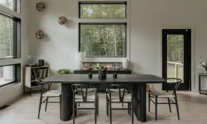 Mesa de comedor moderna con sillas de madera y asientos de mimbre. Un jarrón blanco y dos candelabros negros decoran la mesa, perfecta para decorar mesa comedor.