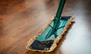 Mopa sobre suelo de madera. Descubre remedios caseros para reparar parquet y mantenerlo como nuevo.