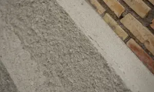 Textura rugosa de un muro de ladrillos y cemento. El acrílico que es este material de construcción, se ve en primer plano.