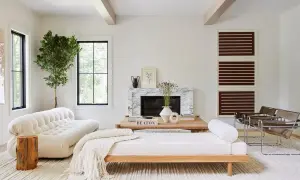 Elegante salón combinar madera y blanco. Sofá blanco texturizado, diván de madera, chimenea de mármol y sillones modernos.