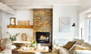Acogedor salón nórdico rústico con chimenea de piedra, vigas de madera y decoración natural.