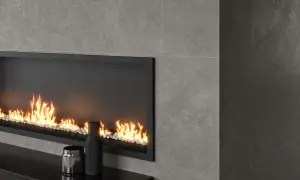 Chimenea moderna con revestimiento de piedra gris y fuego acogedor.