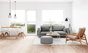 Elegante salón comedor con sofá gris, mesa de centro y sillas blancas. La iluminación moderna ayuda a combinar lamparas salon comedor.