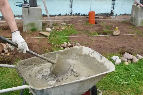 Mezclando cemento y agregados en una carretilla para saber como hacer hormigon.