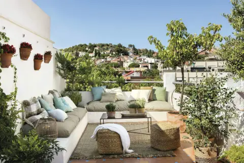 Cómodas terrazas chill out con vistas a la ciudad, cojines coloridos y plantas verdes.