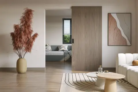 Instalar puerta corredera de madera en un salón moderno. Un jarrón con pampas secas y un cuadro abstracto decoran el espacio.