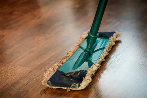 Mopa sobre suelo de madera. Descubre remedios caseros para reparar parquet y mantenerlo como nuevo.