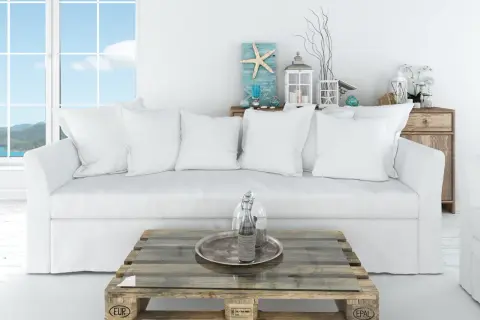 Sofá blanco y mesa de palets con decoración náutica, ideal para un salón decoración ibicenca.