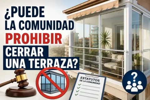 ¿Puede la comunidad prohibir cerrar una terraza? Imagen con martillo de juez, símbolo de prohibición y estatutos.