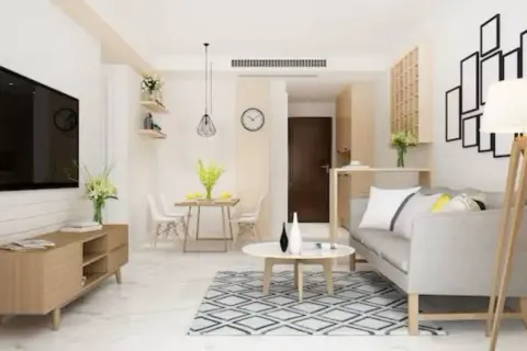 Salones pequeños rectangulares con sofá gris, mesa de centro, alfombra, comedor y TV.