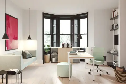 Un moderno despacho en casa con sofá, escritorio, silla ergonómica y estanterías.