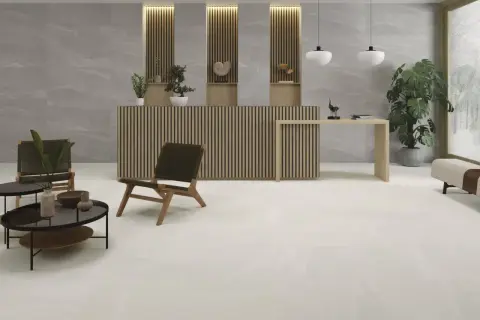Recepción moderna con suelo cerámico o porcelánico de gran formato en tonos claros, mobiliario de madera y plantas.