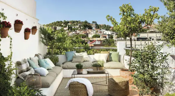 Cómodas terrazas chill out con vistas a la ciudad, cojines coloridos y plantas verdes.