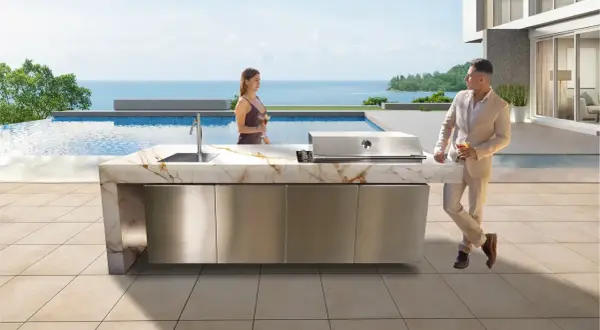 Pareja disfruta de cócteles junto a una piscina infinita, con una moderna cocina exterior y barbacoas de obra caseras.