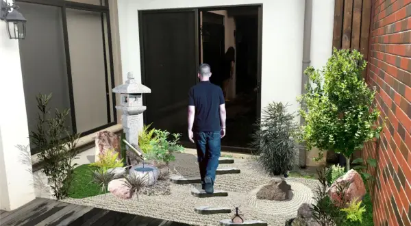 Un hombre camina hacia un sereno **patio jardín japonés en casa**, con una linterna de piedra y un estanque de bambú.