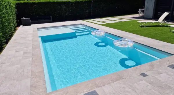 Piscina de obra moderna con escalones y flotadores. Un ejemplo de como hacer una piscina de obra para disfrutar del verano.