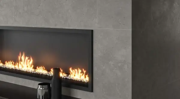 Chimenea moderna con revestimiento de piedra gris y fuego acogedor.