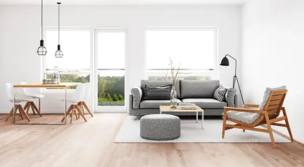 Elegante salón comedor con sofá gris, mesa de centro y sillas blancas. La iluminación moderna ayuda a combinar lamparas salon comedor.