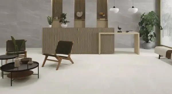 Recepción moderna con suelo cerámico o porcelánico de gran formato en tonos claros, mobiliario de madera y plantas.
