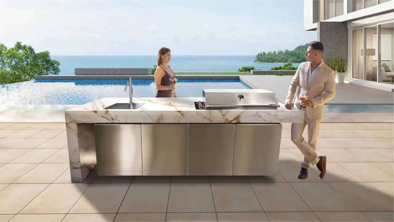 Pareja disfruta de cócteles junto a una piscina infinita, con una moderna cocina exterior y barbacoas de obra caseras.