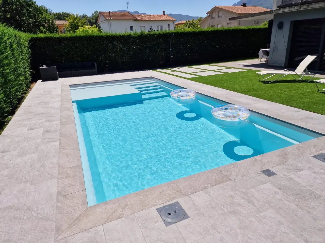 Piscina de obra moderna con escalones y flotadores. Un ejemplo de como hacer una piscina de obra para disfrutar del verano.