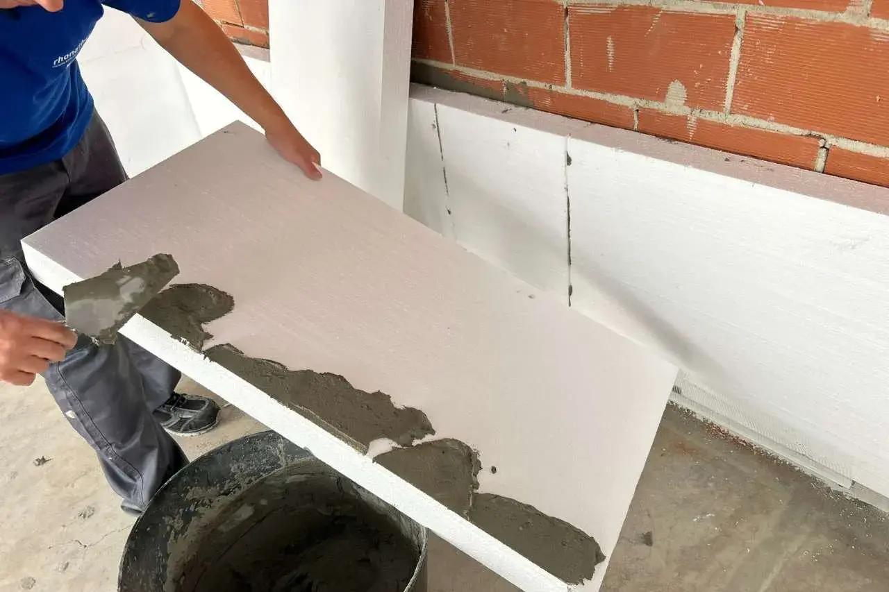 Aplicando mortero sobre poliestireno extruido para aislamiento.