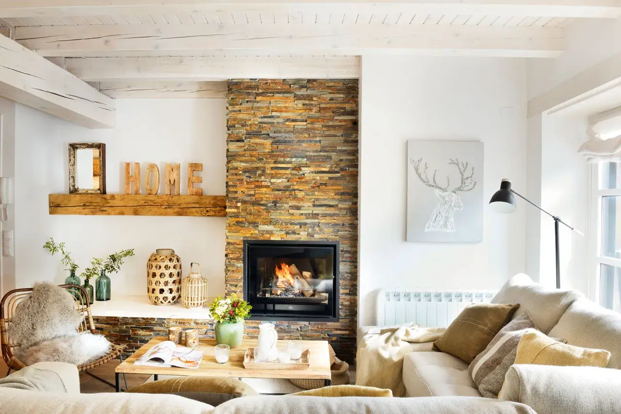 Acogedor salón nórdico rústico con chimenea de piedra, vigas de madera y decoración natural.