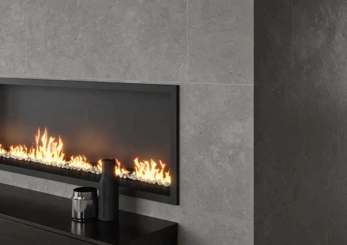 Chimenea moderna con revestimiento de piedra gris y fuego acogedor.