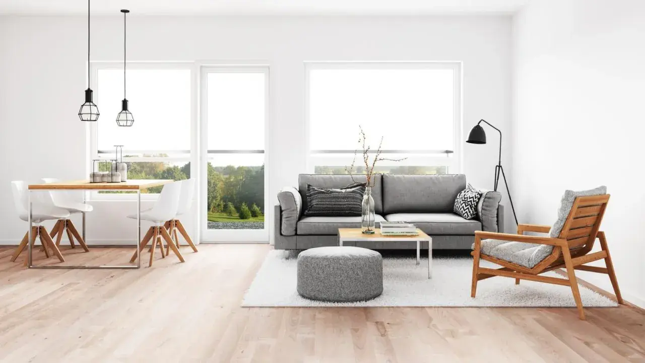 Elegante salón comedor con sofá gris, mesa de centro y sillas blancas. La iluminación moderna ayuda a combinar lamparas salon comedor.