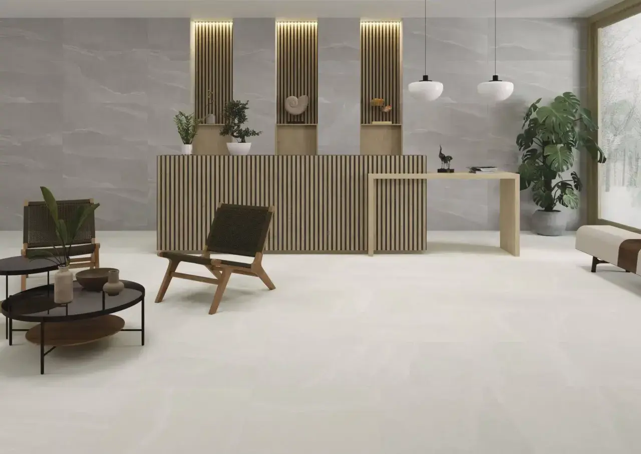 Recepción moderna con suelo cerámico o porcelánico de gran formato en tonos claros, mobiliario de madera y plantas.