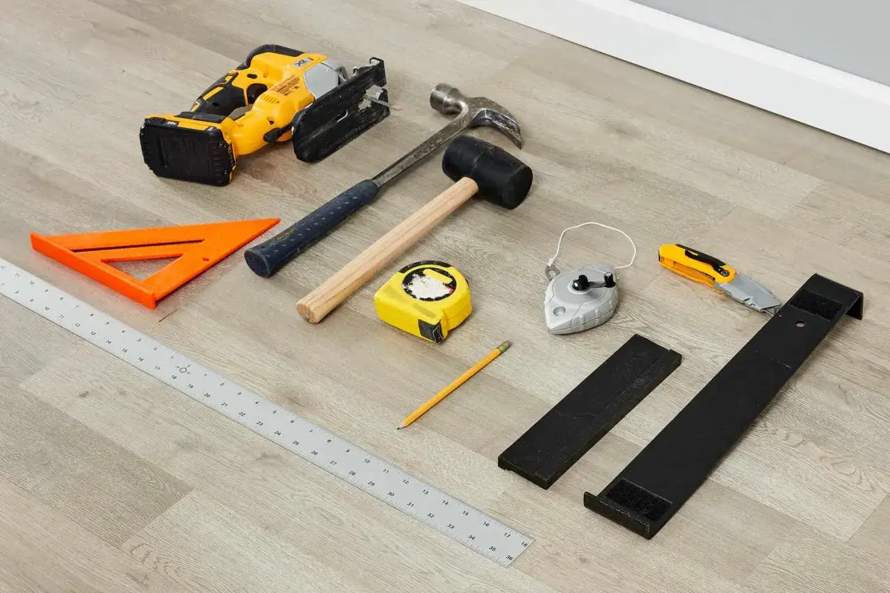 Herramientas para saber como poner suelo laminado: sierra de calar, martillos, cinta m&eacute;trica, escuadra, l&aacute;piz, plomada, c&uacute;ter y soportes.