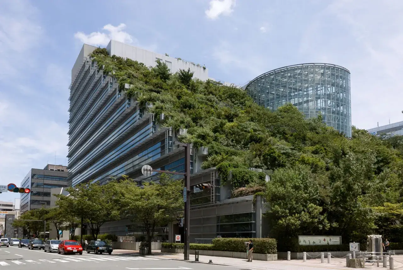 Edificio moderno cubierto de vegetaci&oacute;n, un ejemplo de eficiencia energ&eacute;tica en arquitectura.