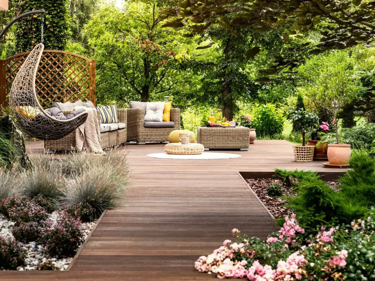 Un espacio de relajaci&oacute;n con muebles de mimbre, columpio y plantas, ideal para inspirarse en planos de jardines modernos.