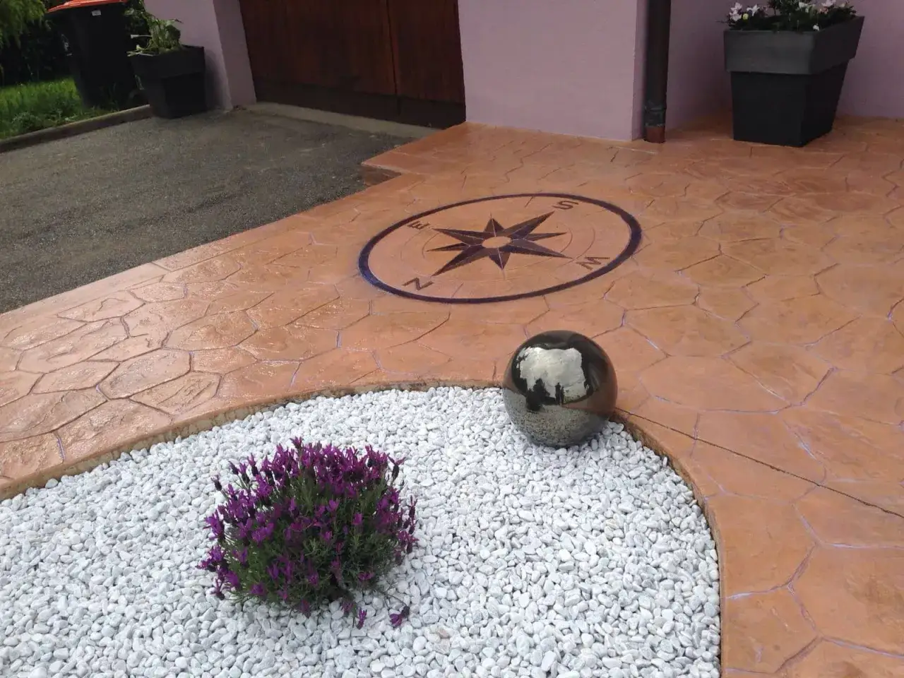 Detalle de cómo hacer hormigón impreso con un diseño de brújula y una esfera decorativa.