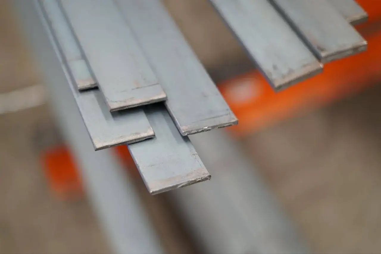 Varias pletinas metálicas apiladas, listas para ser usadas en construcción o industria.