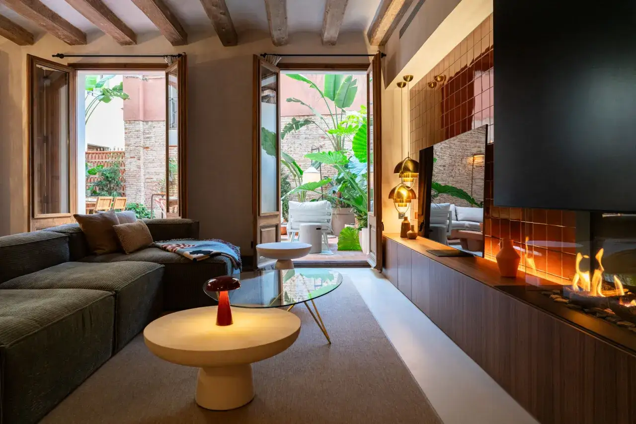Acogedor sal&oacute;n con chimenea y acceso a patio interior. El interiorismo de estudios modernos combina confort y dise&ntilde;o.