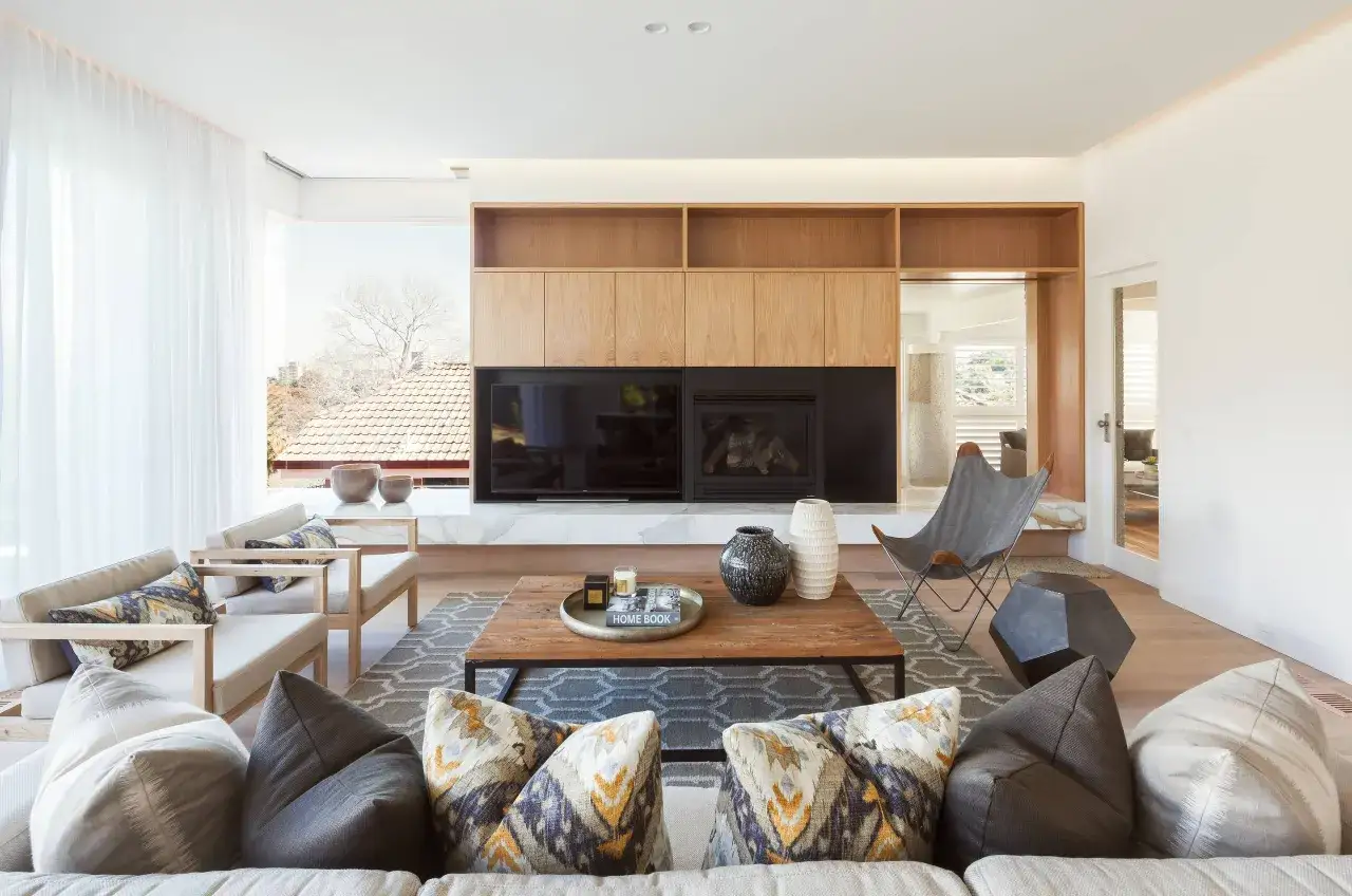 Elegante salón combinar madera y blanco. Sofás cómodos, chimenea moderna y estanterías de madera.