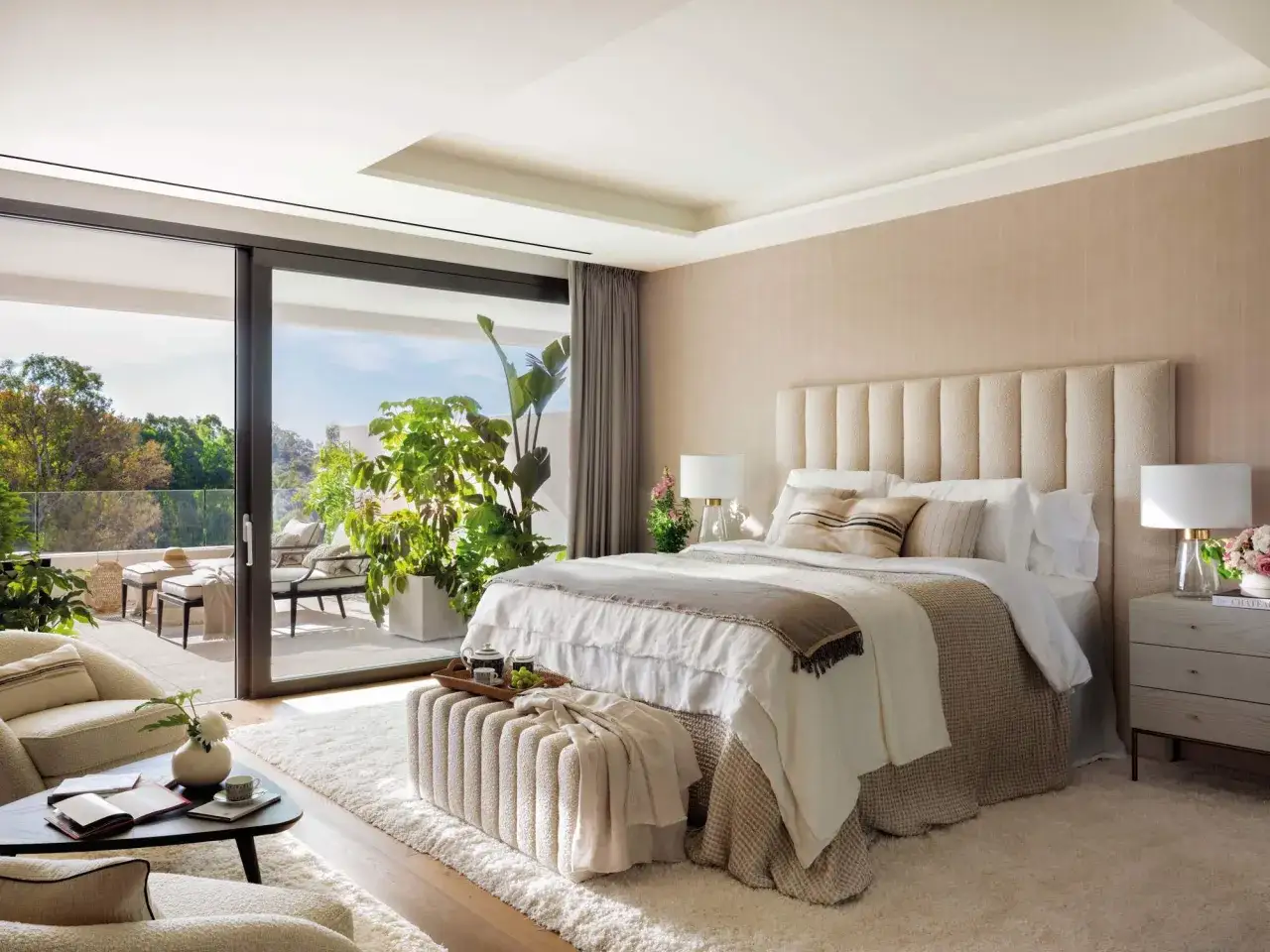 Habitaci&oacute;n serena con cama king, terraza y sillones. Tonos neutros y texturas suaves crean un ambiente acogedor, ideal para inspirarse en colores para habitaciones.