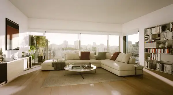 Elegante decoracion salon con sofá modular beige, mesa de centro redonda, estantería llena de libros y vistas a la ciudad.
