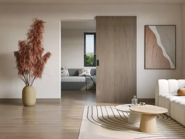 Instalar puerta corredera de madera en un salón moderno. Un jarrón con pampas secas y un cuadro abstracto decoran el espacio.