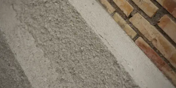 Textura rugosa de un muro de ladrillos y cemento. El acrílico que es este material de construcción, se ve en primer plano.