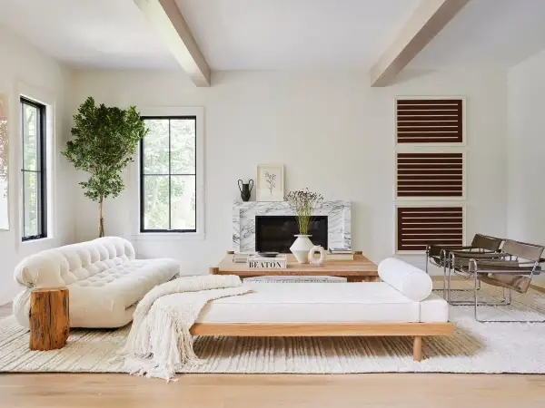 Elegante salón combinar madera y blanco. Sofá blanco texturizado, diván de madera, chimenea de mármol y sillones modernos.